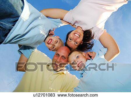 Low angle view of a family in a huddle View Large Photo Image Stock Image - Low angle view of a family in a huddle. Fotosearch
