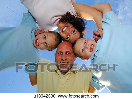 Stock Image - Low angle view of a family in a huddle. Fotosearch