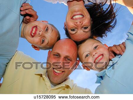 Low angle view of a family in a huddle View Large Photo Image Stock Photography - Low angle view of a family in a huddle. Fotosearch