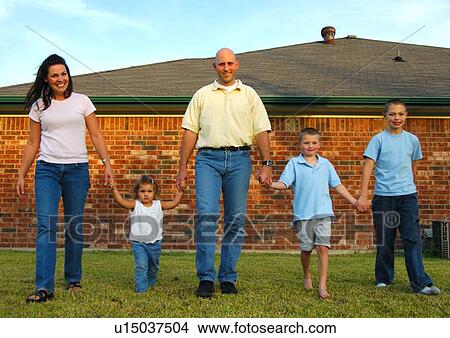 Mid adult couple walking in a park with their three children View Large Photo Image Picture - Mid adult couple walking in a park with their three children. Fotosearch