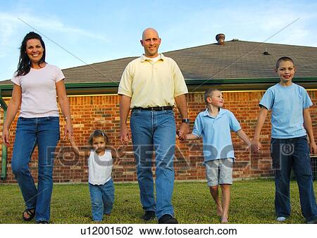 Portrait of a mid adult couple walking in a park with their three children View Large Photo Image Stock Image - Portrait of a mid adult couple walking in a park with their three children. Fotosearch