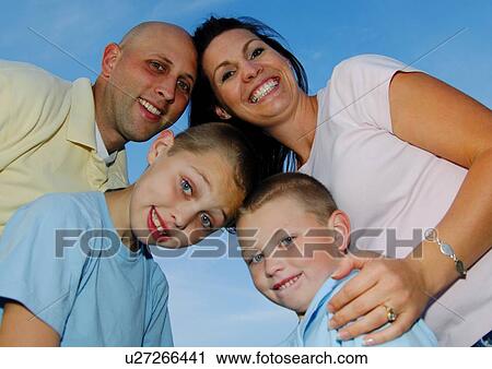 Portrait of a mid adult couple with their two sons smiling View Large Photo Image Stock Image - Portrait of a mid adult couple with their two sons smiling. Fotosearch