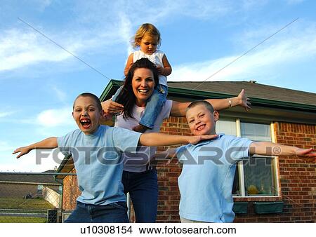 Picture - Portrait of a mid adult woman playing with her three children. Fotosearch