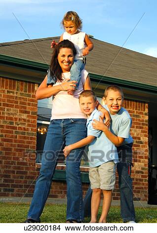 Picture - Portrait of a mid adult woman playing with her three children. Fotosearch