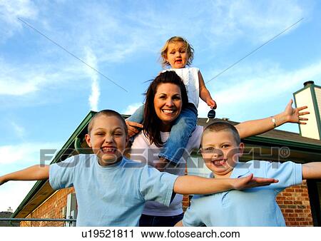 Portrait of a mid adult woman playing with her three children View Large Photo Image Stock Image - Portrait of a mid adult woman playing with her three children. Fotosearch