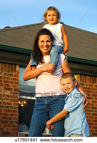 Stock Image - Portrait of a mid adult woman smiling with her son and daughter. Fotosearch