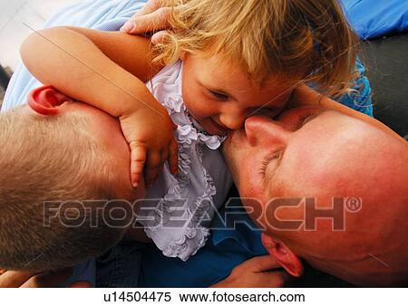 Close-up of a mid adult man with his children View Large Photo Image Stock Photography - Close-up of a mid adult man with his children. Fotosearch