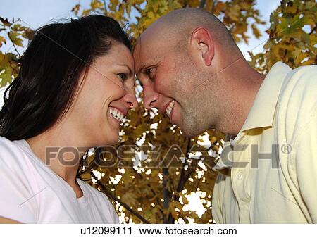 Stock Image - Low angle view of a mid adult couple smiling. Fotosearch