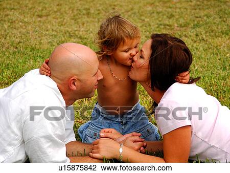 Stock Image - Mid adult couple with their daughter in a park. Fotosearch