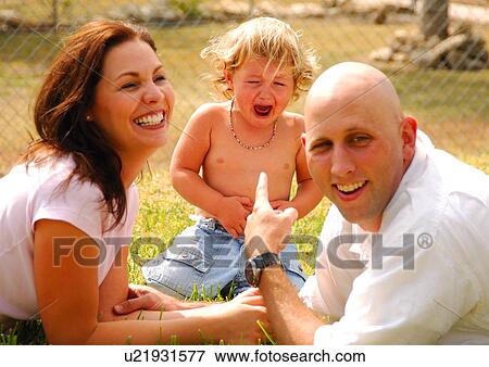 Stock Photo - Mid adult couple with their daughter in a park. Fotosearch
