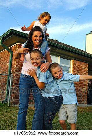 Stock Image - Mid adult woman playing with her children. Fotosearch