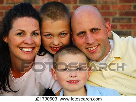 Stock Image - Portrait of a mid adult couple smiling with their children. Fotosearch