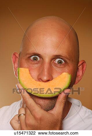 Portrait of a mid adult man holding a slice of cantaloupe View Large Photo Image Stock Image - Portrait of a mid adult man holding a slice of cantaloupe. Fotosearch