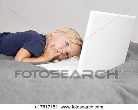 Little girl looking at a laptop View Large Photo Image Stock Image - Little girl looking at a laptop. Fotosearch