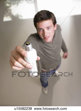Stock Photo - Man fixing a light bulb. Fotosearch