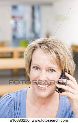 Stock Image - Portrait of a blond woman phoning. Fotosearch