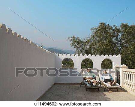 Senior couple sunbathing on balcony terrace View Large Photo Image Stock Image - Senior couple sunbathing on balcony terrace. Fotosearch