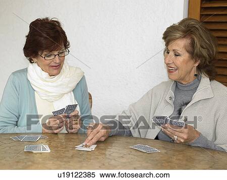 Stock Photography - Two senior women playing cards, smiling. Fotosearch