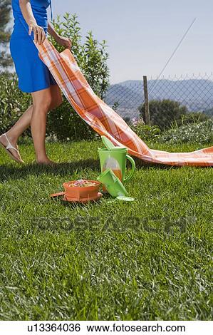 Woman preparing picnic in park, leg-view View Large Photo Image Stock Photograph - Woman preparing picnic in park, leg-view. Fotosearch