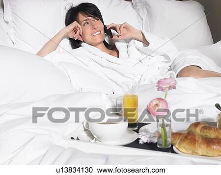 Stock Image - Woman with breakfast in bed. Fotosearch