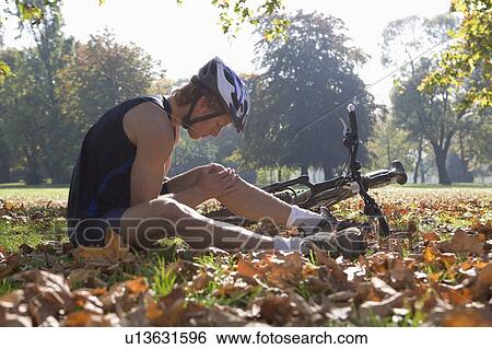 Cyclists looking at injury. View Large Photo Image Stock Photograph - Cyclists looking at injury.. Fotosearch