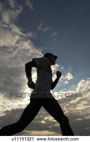 Stock Image - Male runner outdoors, low angle view. Fotosearch