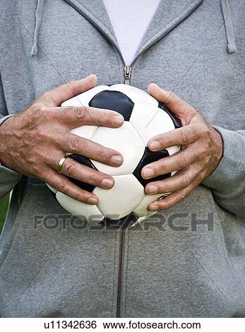 Mans hands holding football View Large Photo Image Stock Photograph - Mans hands holding football. Fotosearch