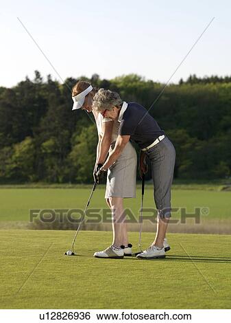 Stock Photograph - Two women on golf green. Fotosearch