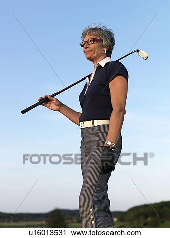 Stock Image - Woman with golf club. Fotosearch