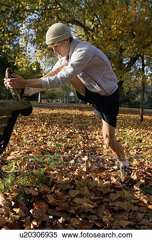 Young man stretching by bench. View Large Photo Image Stock Photography - Young man stretching by bench.. Fotosearch