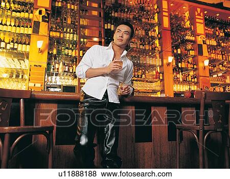Stock Photo - Bar, Beer Bottle, Beer, Bar Counter, Asian Ethnicity. Fotosearch