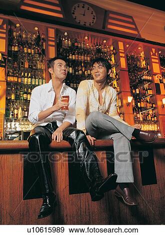 Beer Bottle, Bar Counter, Two People, Sitting, Button Down Shirt, Pant View Large Photo Image Stock Photo - Beer Bottle, Bar Counter, Two People, Sitting, Button Down Shirt, Pant. Fotosearch