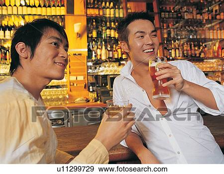 Stock Photo - Rolled Up Sleeves, Cheerful, T-Shirt, Indoor, Asian Ethnicity, Smiling. Fotosearch