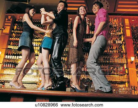 Stock Photograph - Smiling, Asian Ethnicity, Asian, Bar Counter, Button Down Shirt, Amused, Evening Wear. Fotosearch