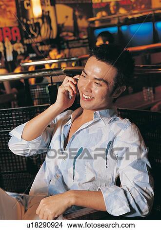 Picture - Waist-Up, Wireless Technology, Sitting, Young Adult, Talking, Indoor. Fotosearch