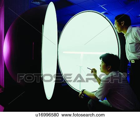 Stock Image - Button Down Shirt, Mid Adult Men, Business, Holding, Concentration, Crouching. Fotosearch