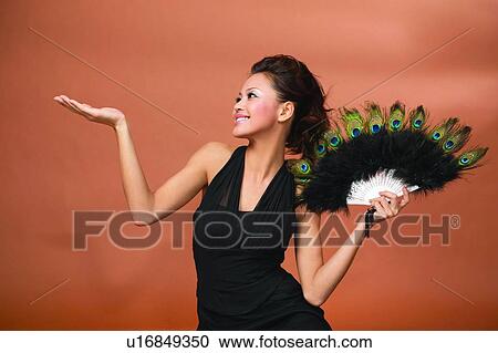 Stock Image - One Young Woman Only, Hand Raised, Asian Ethnicity, Colored Background, One Person. Fotosearch