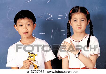 Stock Photograph - asian ethnicity, chalk, black board, 5-6 years. Fotosearch