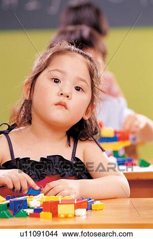 childhood, young, child, indoor, people in background, close up View Large Photo Image Picture - childhood, young, child, indoor, people in background, close up. Fotosearch
