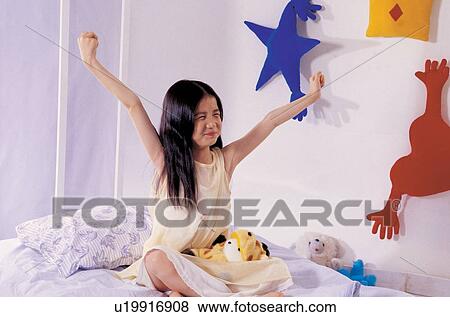 Stock Photo - pillow, asian ethnicity, child, hands in air, culture, eyes closed. Fotosearch