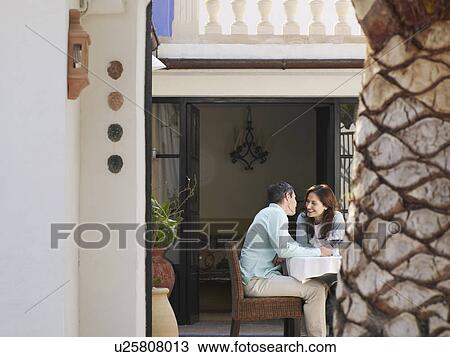 Couple sitting on garden terrace about to kiss View Large Photo Image Stock Image - Couple sitting on garden terrace about to kiss. Fotosearch
