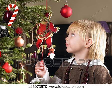Girl playing with christmas decoration View Large Photo Image Stock Image - Girl playing with christmas decoration. Fotosearch