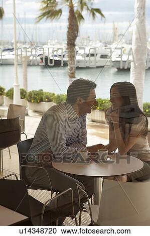 Loving couple sitting outside café by harbour shot through window Alicante, Spain. View Large Photo Image Stock Image - Loving couple sitting outside café by harbour shot through window Alicante, Spain.. Fotosearch
