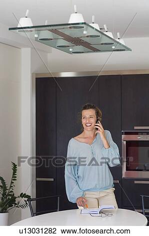 Woman in kitchen talking on phone. View Large Photo Image Stock Image - Woman in kitchen talking on phone.. Fotosearch
