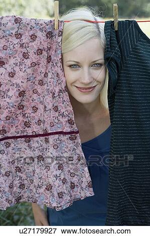 Woman peeking through laundry hanging on clothesline smiling. View Large Photo Image Stock Photo - Woman peeking through laundry hanging on clothesline smiling.. Fotosearch
