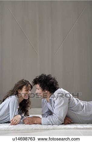 Stock Image - Young couple laying on floor. Fotosearch