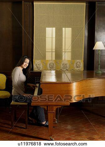 Young woman playing piano, smiling, portrait View Large Photo Image Stock Photo - Young woman playing piano, smiling, portrait. Fotosearch