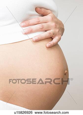 Pregnant woman touching her belly View Large Photo Image Stock Photograph - Pregnant woman touching her belly. Fotosearch