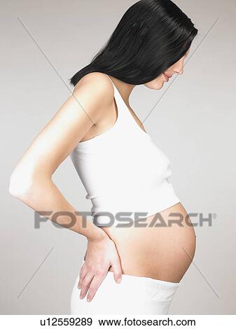Pregnant woman touching her stomach View Large Photo Image Stock Photo - Pregnant woman touching her stomach. Fotosearch