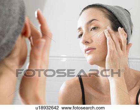 Woman putting on face cream View Large Photo Image Stock Image - Woman putting on face cream. Fotosearch